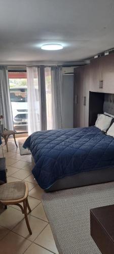 a bedroom with a large blue bed in a room at allen's place in Roodepoort
