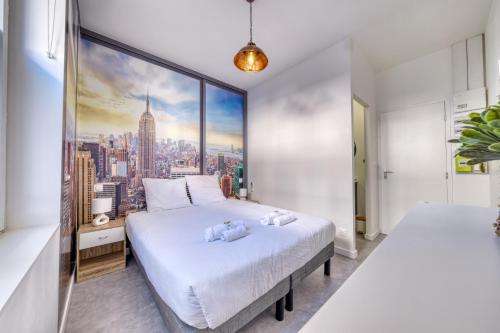 a bedroom with two beds and a large window at La Résidence Courcelles - Climatisation in Reims