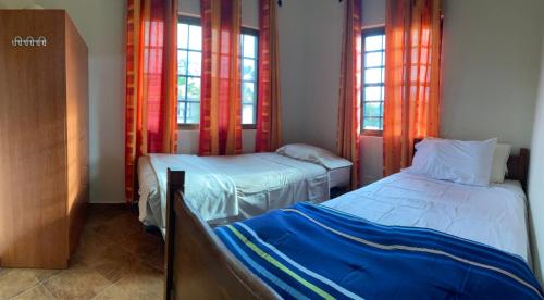 two beds in a room with windows and two bedsvisor at Two Bedroom Home Punta Chame Resort in Pajonal