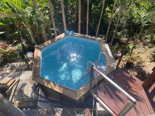 a swimming pool with a chair and a table and a chair at Bungalow dans un écrin de verdure! in Saint-Pierre