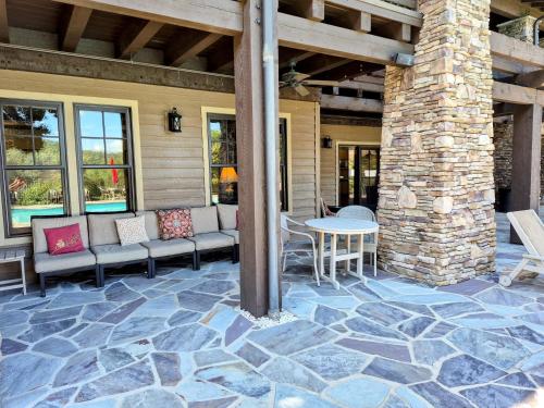 a patio with a table and chairs and a stone pillar at Firefly Cove #202 in Chimney Rock