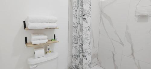 a bathroom with white towels and a shower at Casa Emma Quepos in Quepos