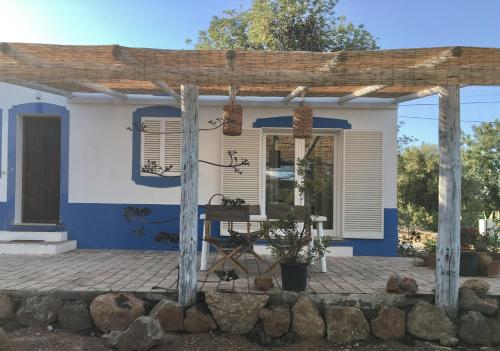 a blue and white house with a table on a patio at Charming Country House in Poço do Álamo