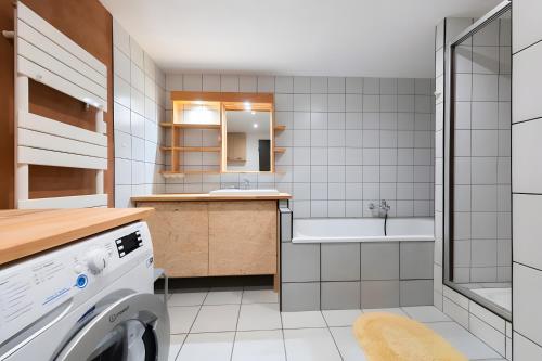 a bathroom with a sink and a washing machine at Gite Nature L'orée Des Etoiles in Soultzeren