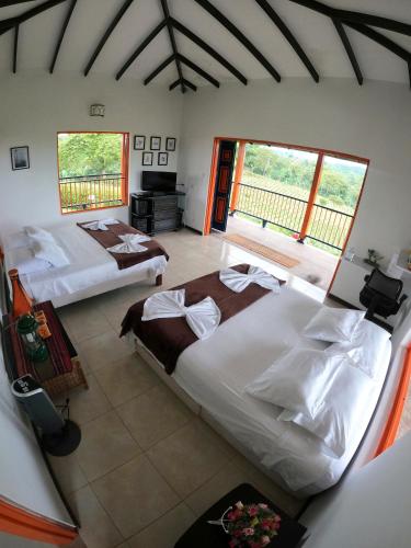 a bedroom with two beds and a balcony at Finca La Coqueta Coffee Farm Stay near Filandia in Filandia