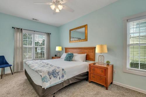 Schlafzimmer mit einem Bett, einem Spiegel und Fenstern in der Unterkunft Thunderbolt Bungalow by Lucky Savannah in Savannah