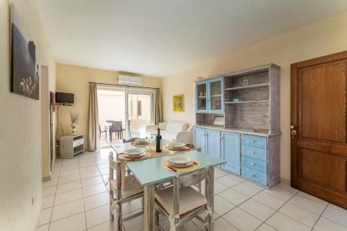 a kitchen with a table and a blue cabinet at Relaxing BaiaDeBahas 1BedApt Bilo4 sleeps4 SeaView in Marinella