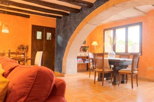 a living room with a table and a dining room at La Festa Dels Sentits, Casa Rural in Sant Martí de Maldá