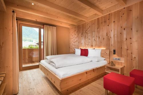 a bedroom with a bed in a wooden wall at Chalet Rudana in Sesto