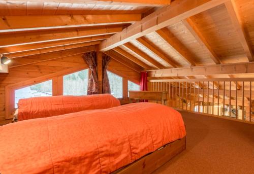オトリュスにあるChalet Lo Capstoaの木製の天井の部屋にベッドが2つある