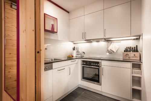 a kitchen with white cabinets and a stove top oven at Chalet Rudana in Sesto