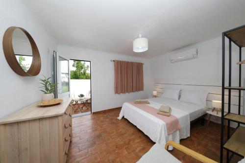 una camera da letto con un letto grande e uno specchio di Acolhedora Casa Tradicional a Asseca