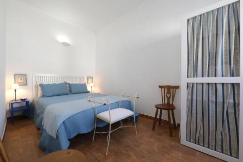 a bedroom with a blue bed and a chair at Casa Tradicional Algarvia in Tavira