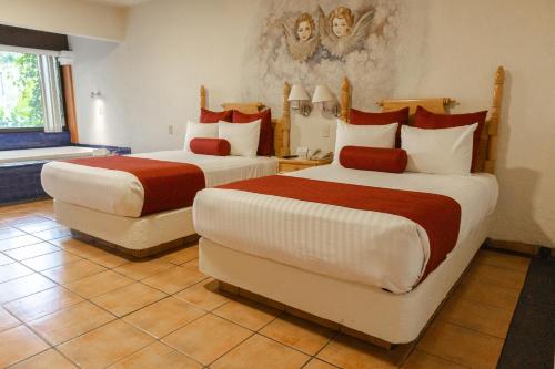 a hotel room with two beds and a window at Hosteria Las Quintas Hotel Restaurante Bar in Cuernavaca