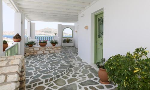 a porch with a green door and potted plants at Villa Isabella in Naousa