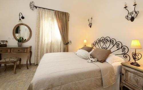a bedroom with a large bed and a mirror at Villa Isabella in Naousa