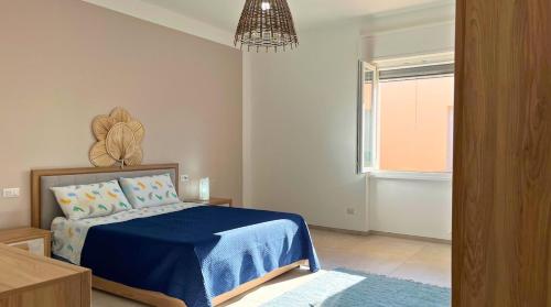 una camera da letto con un letto blu e una finestra di Porto Selvaggio Villa a Santa Caterina di Nardò