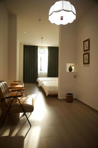 a bedroom with a bed and a chair and a chandelier at Yunxi Courtyard in Zhangzhou