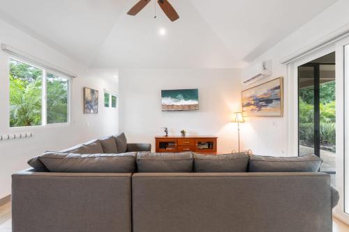 a living room with a large couch and windows at Beautiful Home in a Gated Neighborhood Walking Distance to the Beach with Garden Views and a Pool in Brasilito