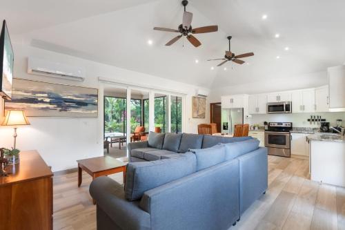 a living room with a blue couch and a kitchen at Beautiful Home in a Gated Neighborhood Walking Distance to the Beach with Garden Views and a Pool in Brasilito