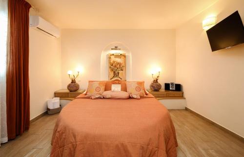 a bedroom with a large bed and a flat screen tv at Villa Isabella in Naousa