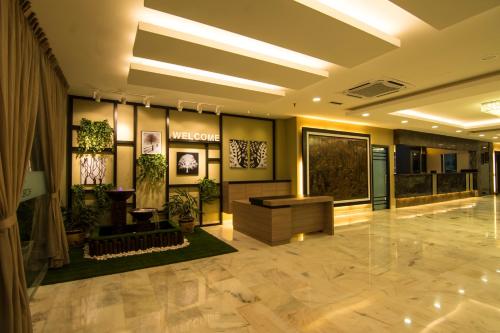 a lobby with a waiting area with plants on the walls at Hotel Anika Kluang in Kluang