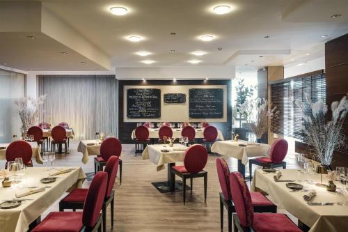 a restaurant with tables and chairs and a chalkboard at NH Vienna Airport Conference Center in Schwechat