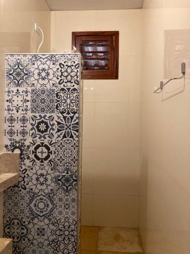 a bathroom with a shower with a tile wall at Casa de hóspedes Balibar Cumbuco in Cumbuco