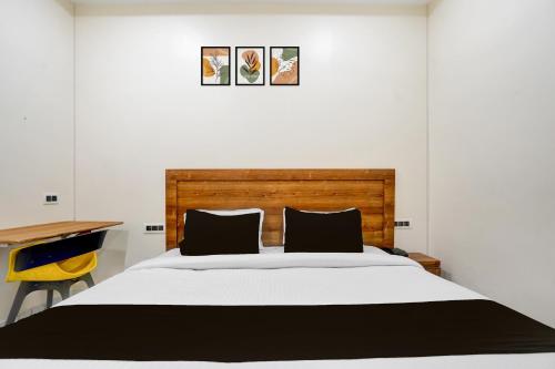 a bedroom with a large bed with a wooden headboard at Hotel O Madhvam in Prayagraj