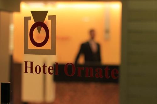 a reflection of a man in a hotel office at Hotel Ornate in Dhaka