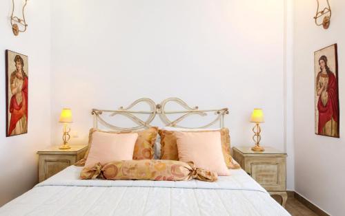 a bedroom with a large bed with two lamps at Villa Isabella in Naousa