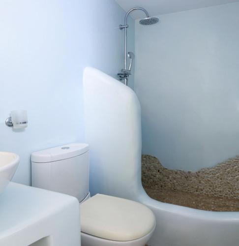 a white bathroom with a toilet and a bath tub at Villa Isabella in Naousa