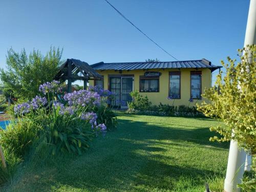 a house with a yard with purple flowers at La Elegida in San Eduardo del Mar