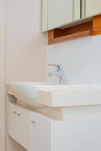 a bathroom with a white sink and white cabinets at Zimbali Hotel Unit 422 Suites in Ballito