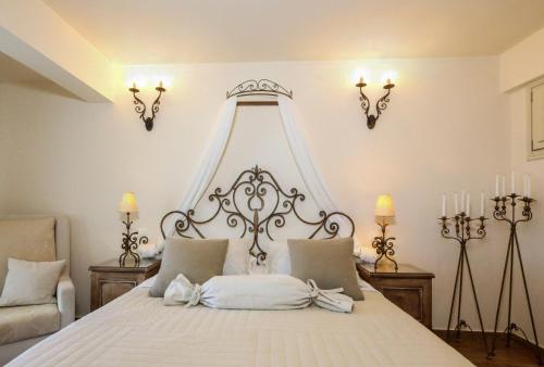 a bedroom with a white bed with a white canopy at Villa Isabella in Naousa