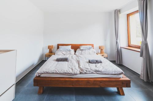 a bedroom with a bed with a wooden bed frame at DOMEK Písařov - apartmány in Písařov