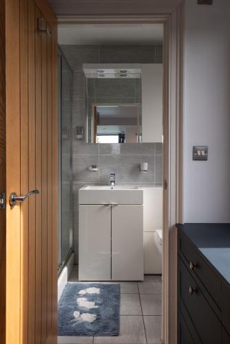 a bathroom with a white sink and a mirror at Trelawney in Yelverton