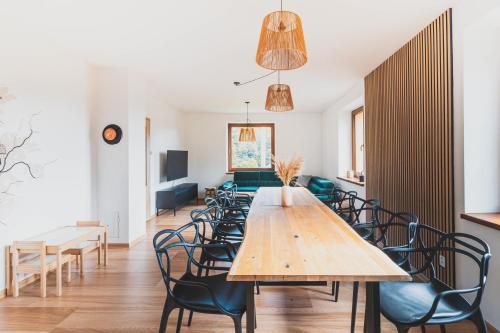 a dining room with a wooden table and chairs at DOMEK Písařov - apartmány in Písařov