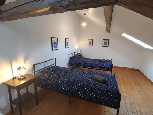 a bedroom with two beds and a table with a lamp at La Crécynade - near Disneyland and Parrot World in Crecy la Chapelle