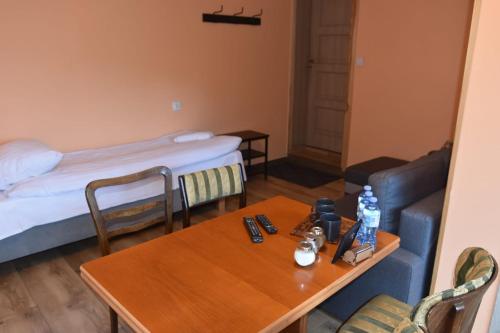 a room with a table and a couch and a bed at Pokoje Mira in Torzym