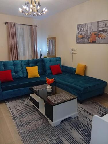a living room with a blue couch and a coffee table at JO Fully Furnished Two Bedroom in Kitengela 