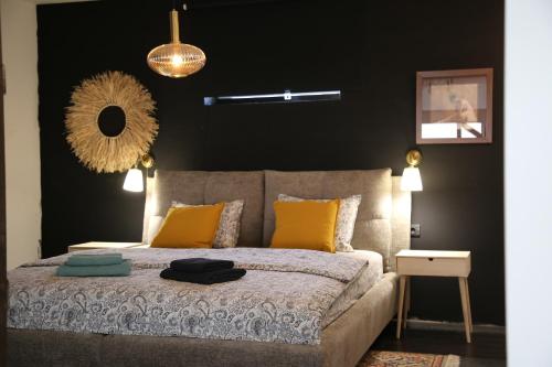 a bedroom with a bed with yellow pillows and a mirror at Industrial Apartment in Kula