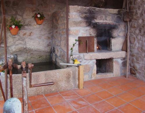 a kitchen with a stove and a stone wall at Casa de Campo Patio do Avo in Routar