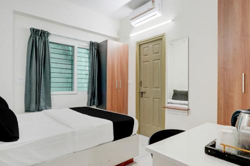 a white bedroom with a bed and a window at Hotel O Arrow Inn in Bengaluru