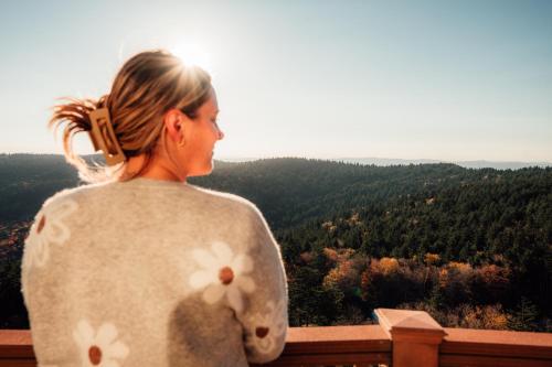 a woman standing on a balcony looking out at the forest at Remodeled Ski In-Out - 305 Soaring Eagle - Luxury! in Dunmore