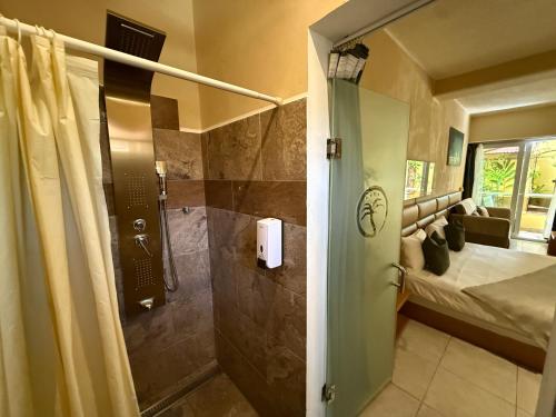 a bathroom with a shower and a bed in a room at Sosua Inn Hotel in Sosúa