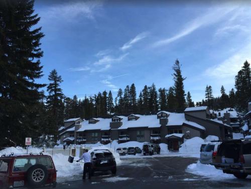 a snow covered building with cars parked in a parking lot at Chamonix Year-Round Fun with Shared Pool in Mammoth Lakes