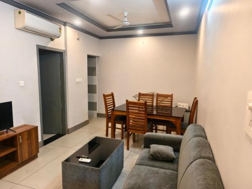 Una sala de estar con un sofá y un comedor. en Kovoor residency, en Thiruvalla