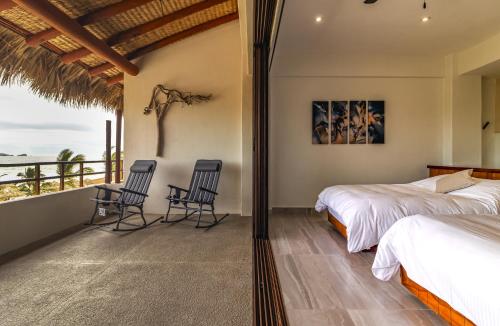 ein Schlafzimmer mit zwei Betten und einem Balkon in der Unterkunft El Secreto Residencial in Ixtapa-Zihuatanejo International