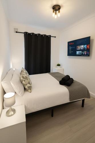 a bedroom with a large bed with a black curtain at Shalom Stay London in London